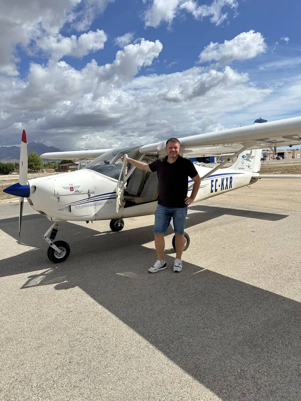 Standing beside a light aircraft on the apron