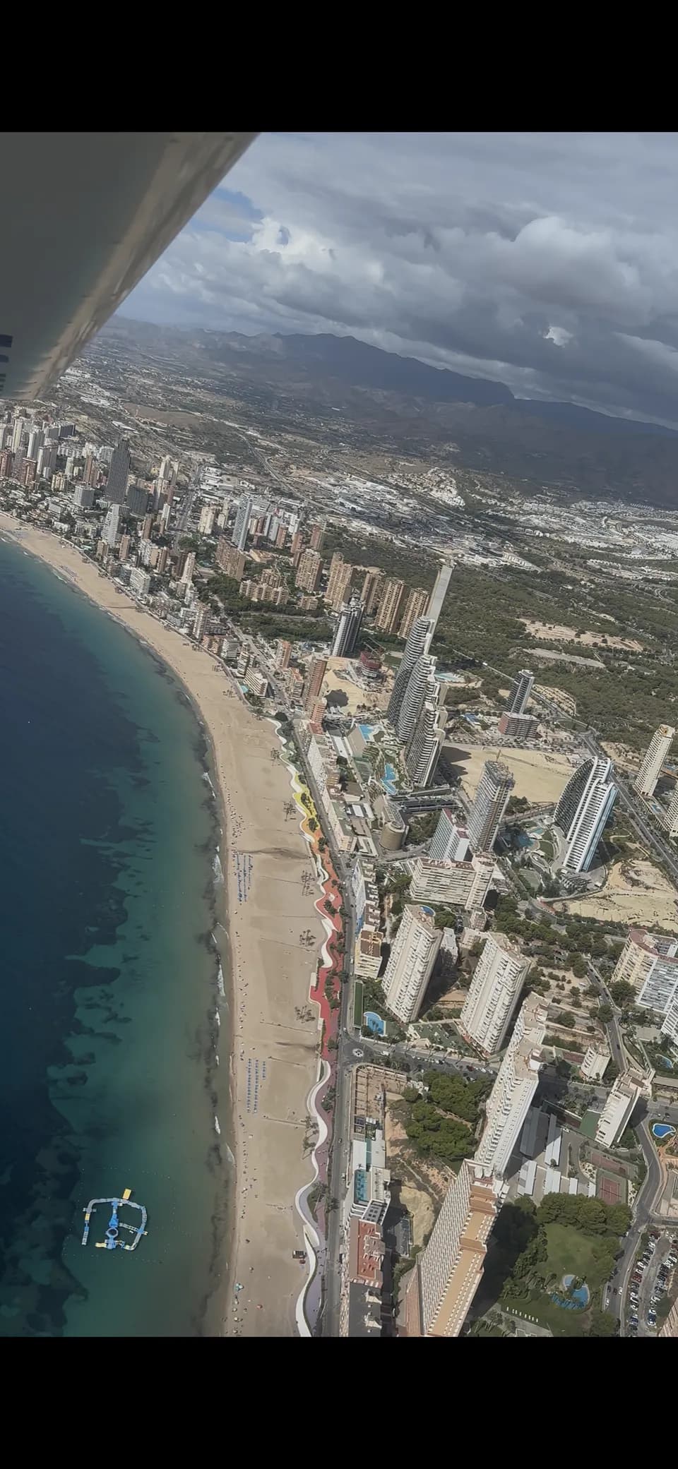 Playa y edificios costeros bajo el ala